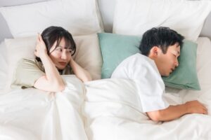 男性のいびきがうるさくて困っている女性の写真