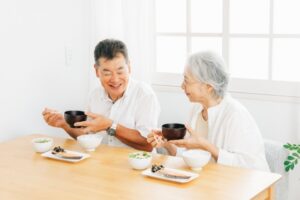 二人の男女が笑顔で食事をする写真