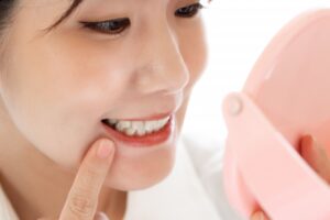 鏡で自分のお口の中を確認する女性の写真