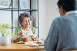 笑顔で食事を楽しむシニア女性の写真